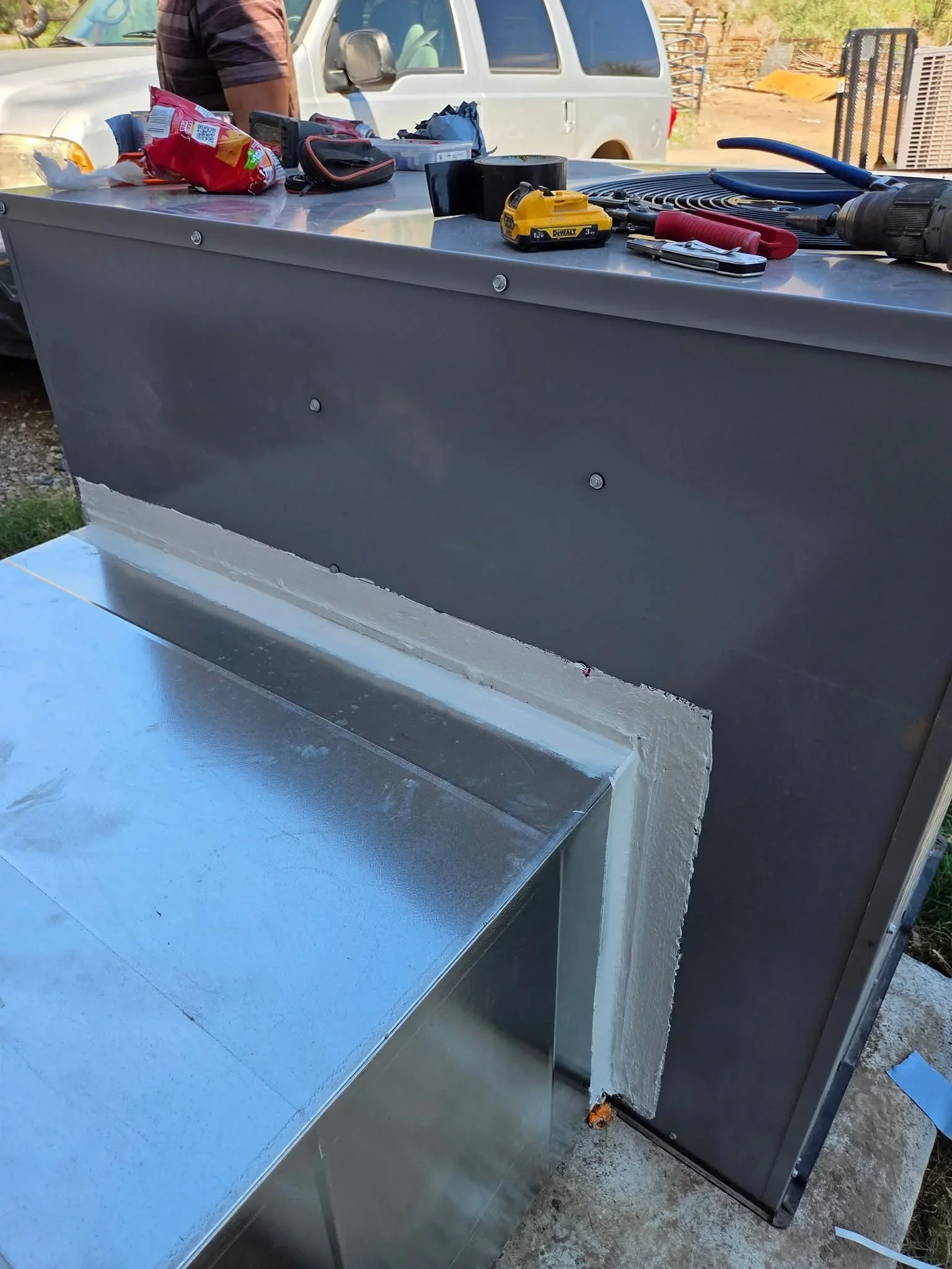 Gray metal HVAC plenum box with sealed seams and return air chamber installed in truck bed