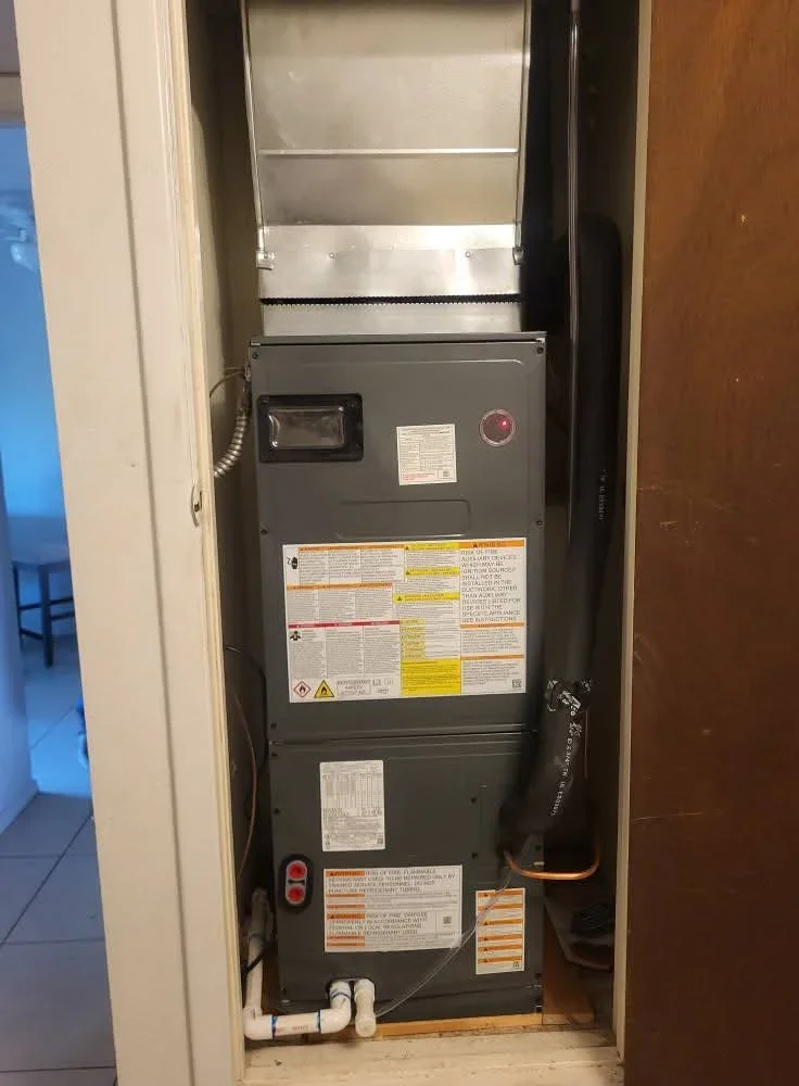 New furnace unit installed in closet with metal plenum, ductwork, and safety labels